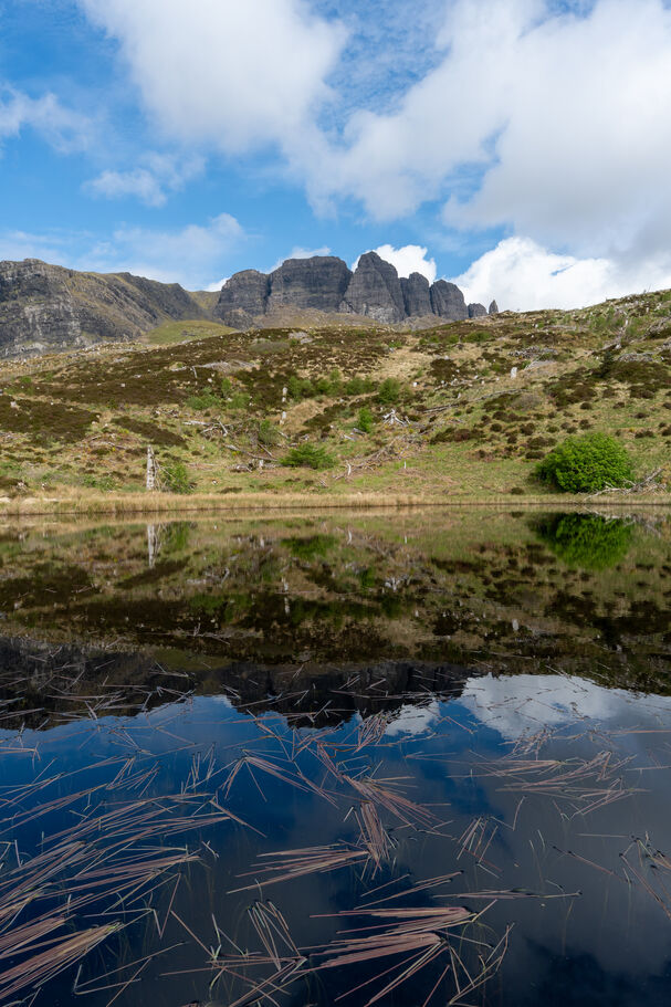 Le Old Man of Storr se reflétant dans un loch de montagne